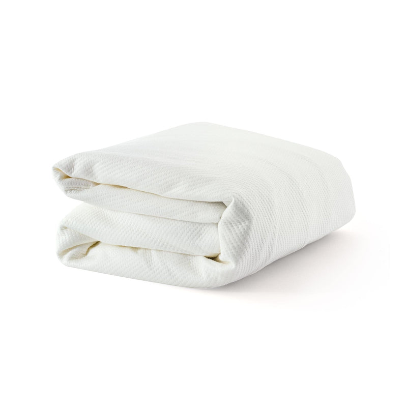 White knitted blanket folded neatly, showcasing a soft texture, ideal for cozy home decor and comfort.