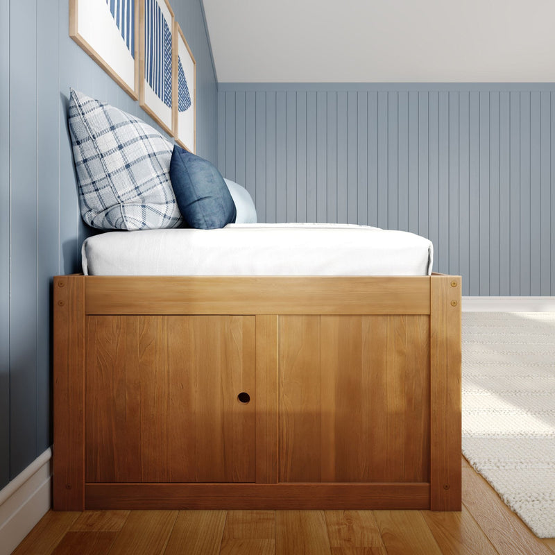 Wooden platform bed with white bedding and blue plaid and navy pillows against light-blue vertical shiplap wall in a modern coastal farmhouse bedroom