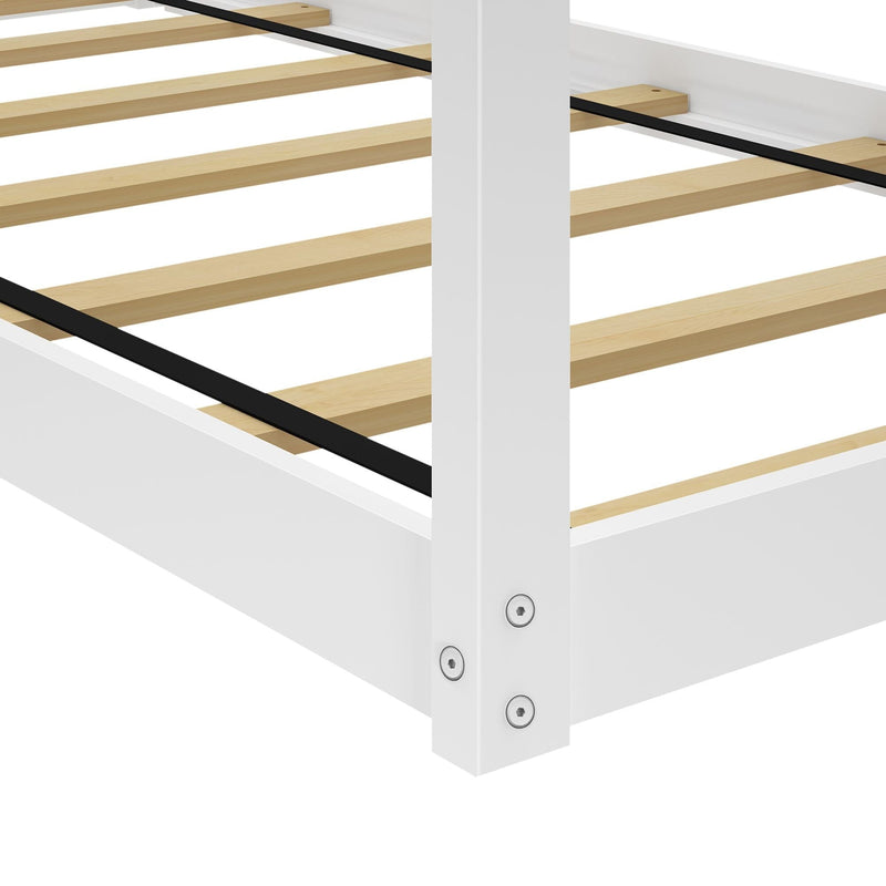 White wooden slatted bed frame close-up showing natural wood slats and black metal center support on a platform bed base