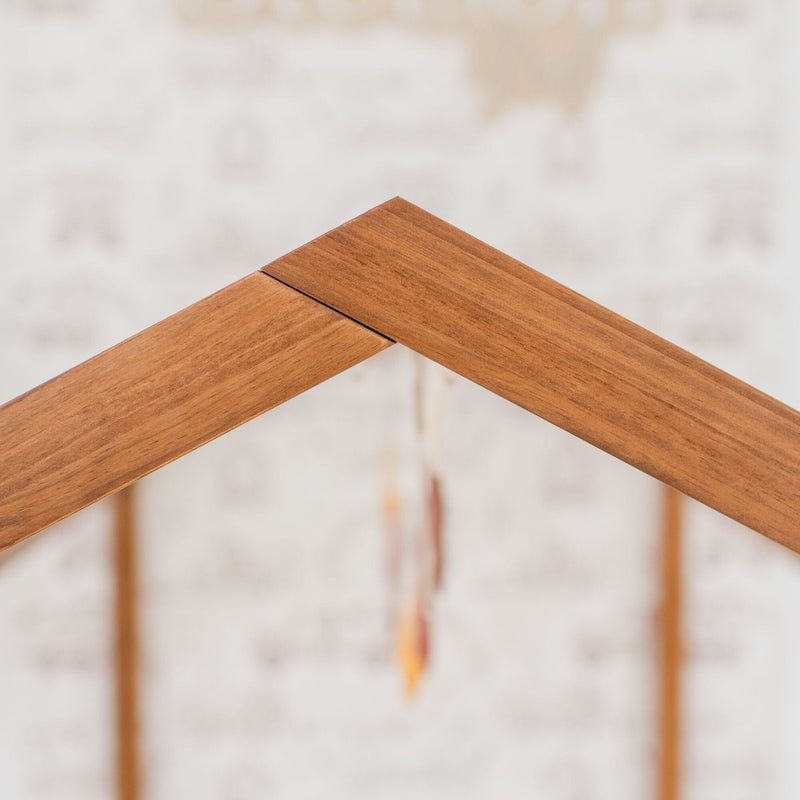 Close-up of interlocking natural wood rafters forming a roof peak on a residential construction site