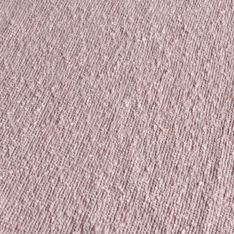 Close-up blush pink bouclé fabric texture — soft woven upholstery or carpet material