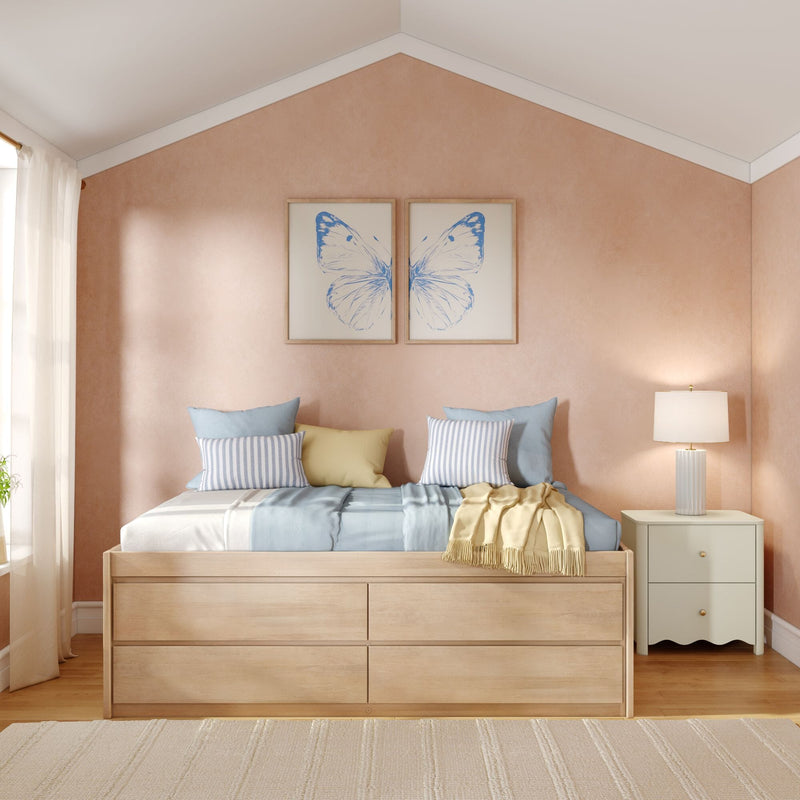 Cozy pastel bedroom with pink textured accent wall, wooden platform bed with storage drawers, blue and yellow bedding, striped pillows and butterfly wall art