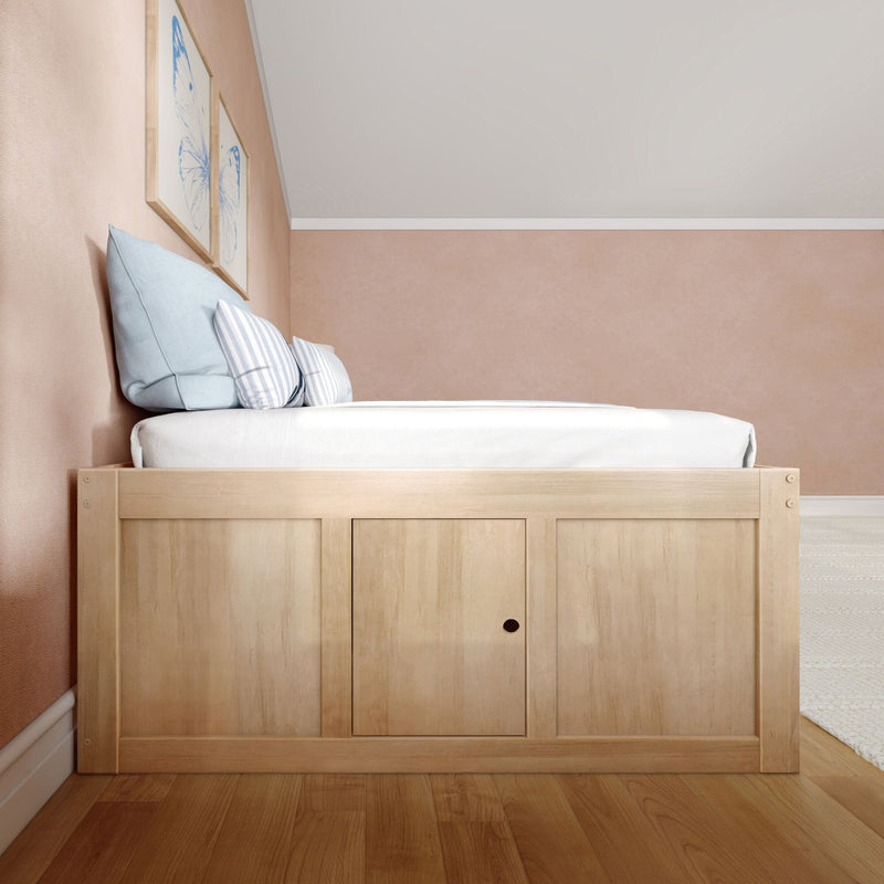 Minimalist bedroom with wooden platform storage bed, light blue and striped pillows, pastel pink walls and framed butterfly art