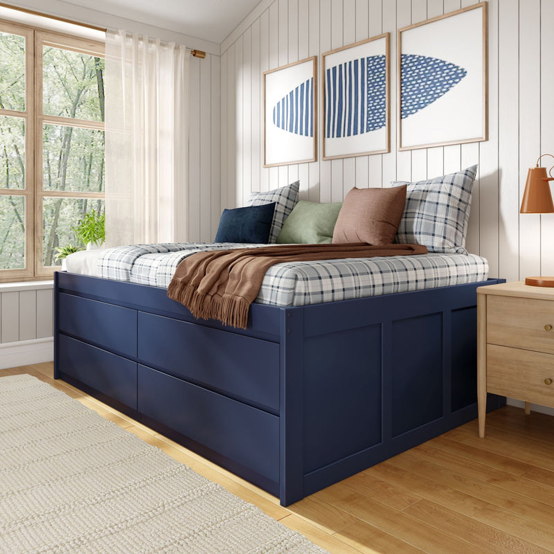 Cozy modern farmhouse bedroom with navy storage bed, plaid bedding and layered pillows, wood nightstand, abstract blue wall art and large window with sheer curtains