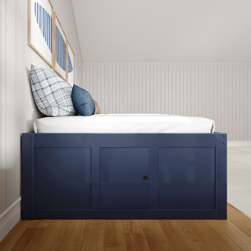 Coastal navy blue wooden bed frame with white bedding, plaid and denim throw pillows against white shiplap wall with framed blue abstract art on hardwood floor