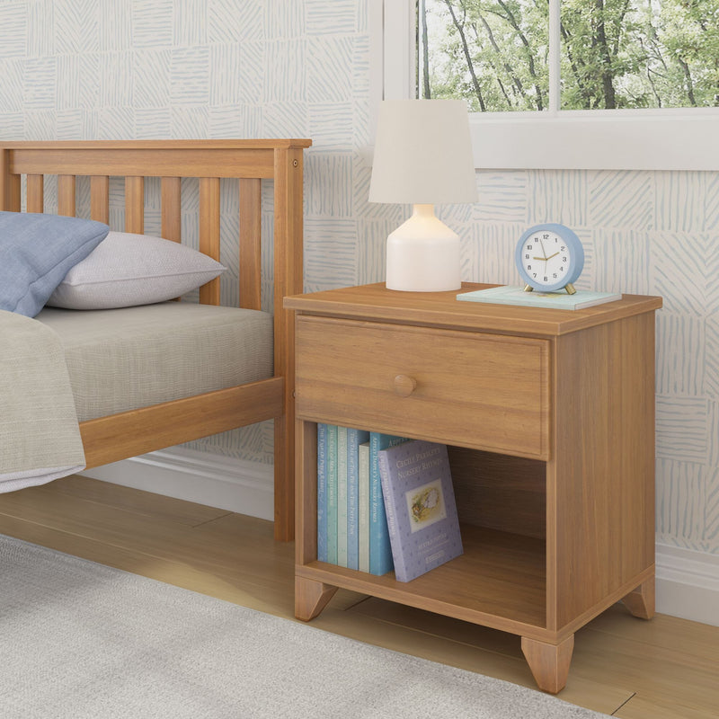Wooden bedside table with books, lamp, and clock in cozy bedroom setting.