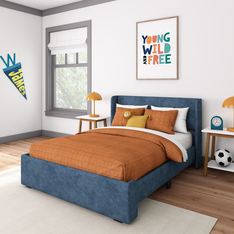 Kids bedroom with blue upholstered bed and orange bedding, Young Wild and Free poster, nightstand lamp, window, soccer ball