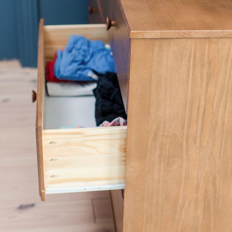 Open oak dresser drawer with folded clothes — wooden bedroom dresser storage and organization