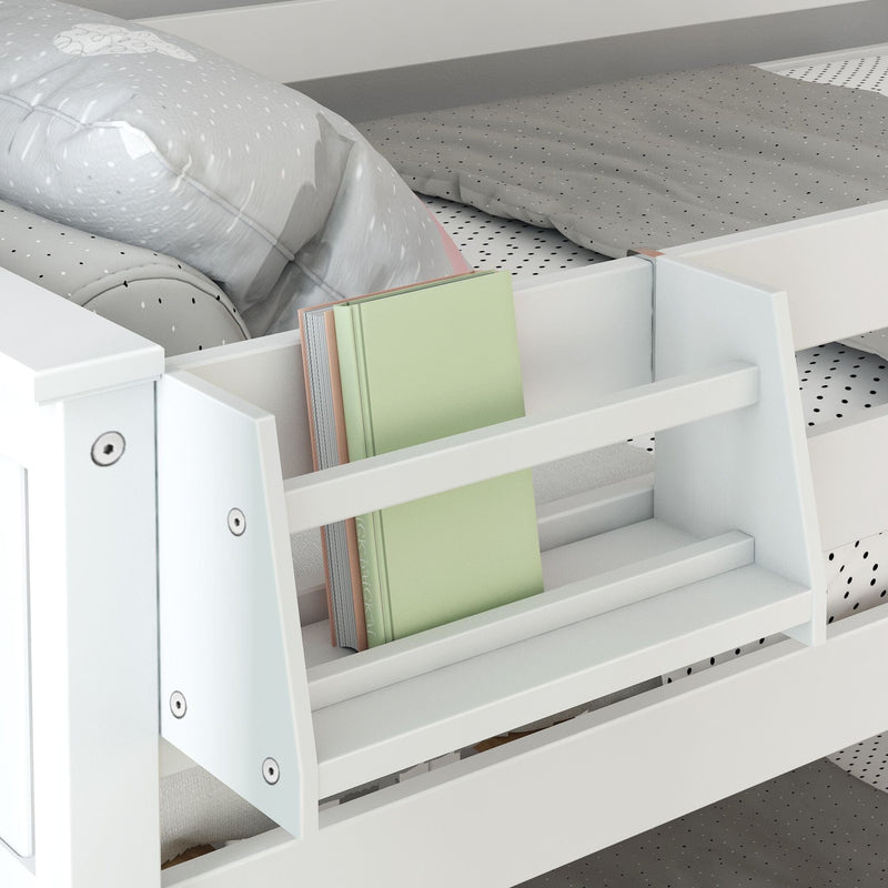 White wooden kids' bed with built-in bookshelf, gray polka-dot bedding and pale green hardcover book