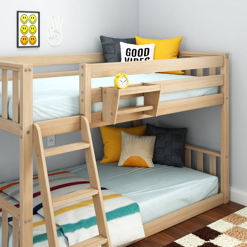 Light wooden kids bunk bed with blue bedding, yellow accent pillows and "Good Vibes" cushion, yellow alarm clock and smiley-face wall art in a modern children's bedroom