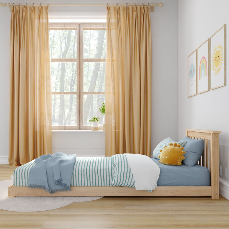 Children's bedroom with wooden bed, blue striped bedding, sun-shaped cushion, mustard curtains, nursery wall art and bright window