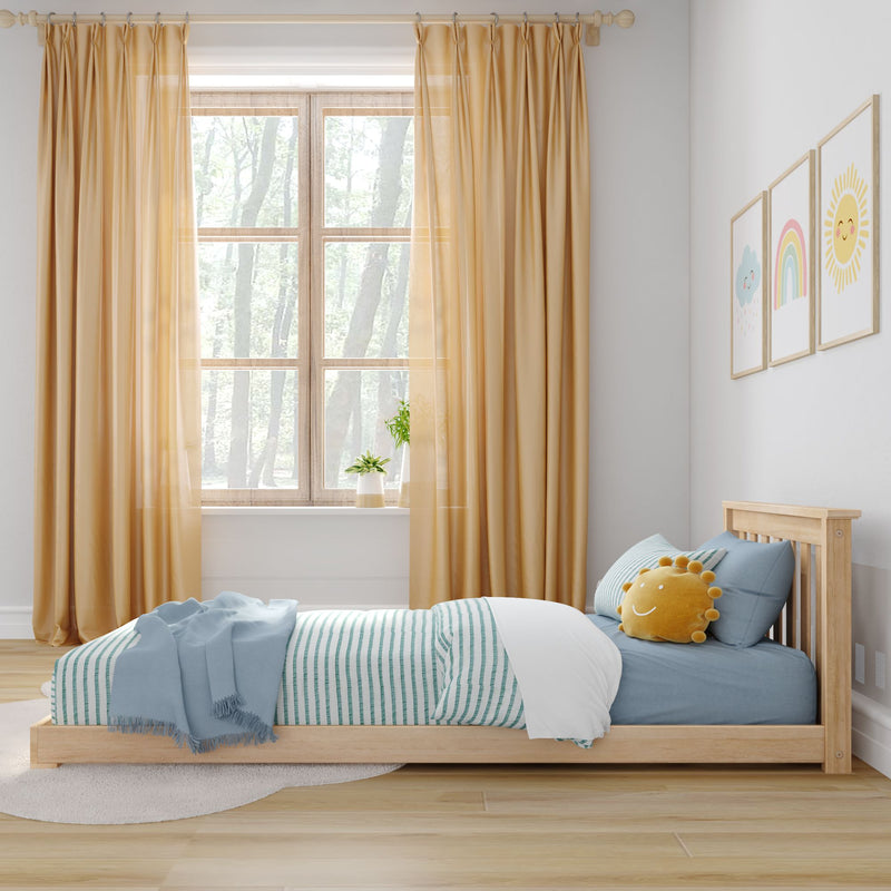 Children's bedroom with wooden bed, blue striped bedding, sun-shaped cushion, mustard curtains, nursery wall art and bright window