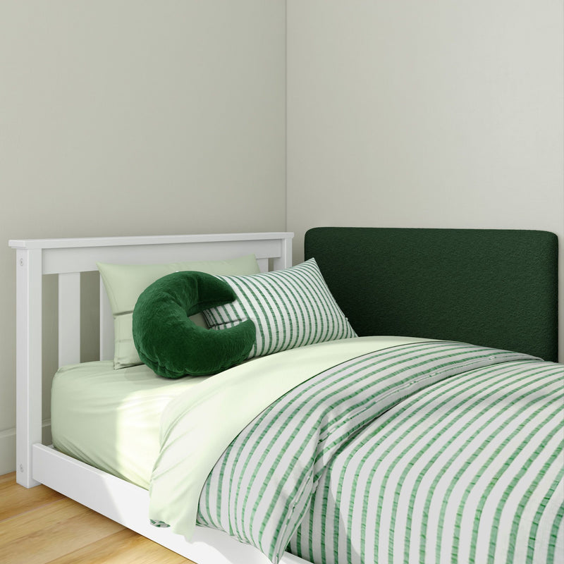 White wooden bed frame with green striped bedding, mint sheets and plush green neck pillow against a pale green wall — nursery decor, green nursery bedding set