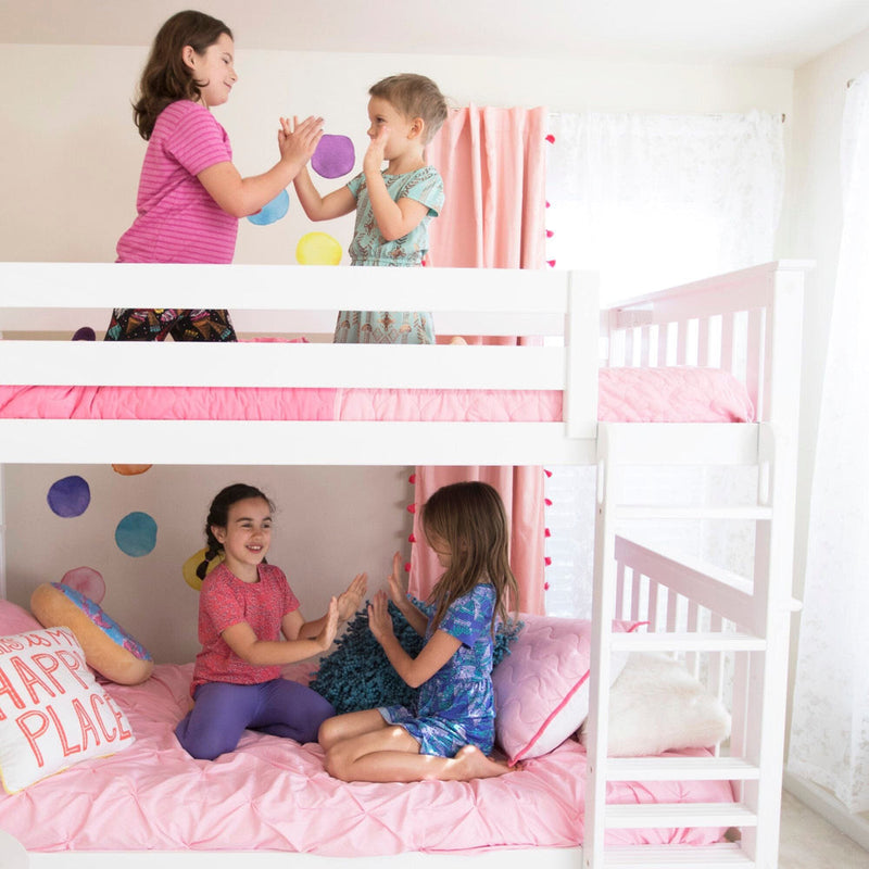 Four children playing on a white wooden bunk bed with pink bedding in a bright, colorful kids' bedroom