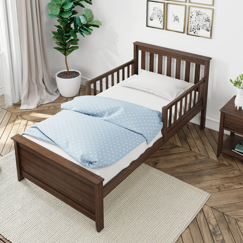 Minimalist children's bedroom nursery with dark walnut wooden toddler bed, light blue polka-dot duvet, white pillow, potted fiddle-leaf fig, framed animal prints, neutral curtains and herringbone hardwood floor