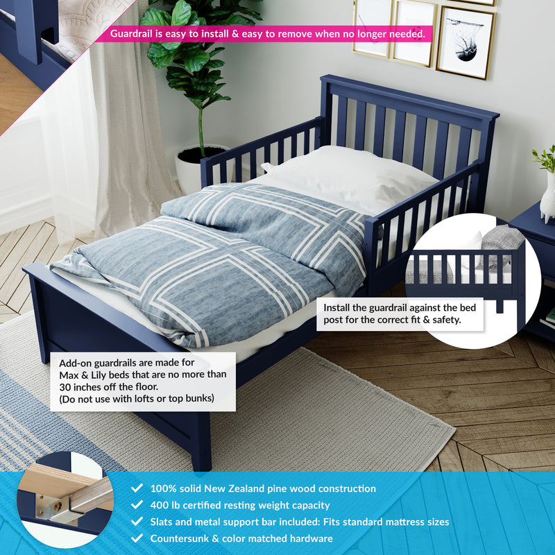Navy blue toddler bed with removable safety guardrail, blue geometric bedding, solid pine slats and metal support construction, staged in a modern kids' bedroom with plant and framed wall art