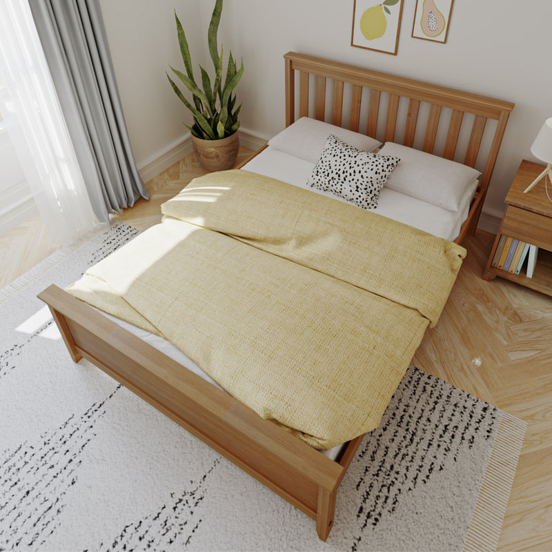 Modern minimalist bedroom with wooden slatted bed frame, yellow duvet and bedding, black-and-white accent pillow, snake plant, sheer curtains and natural light