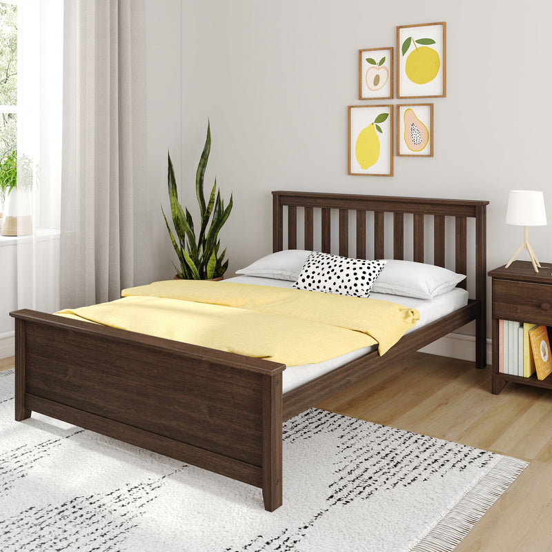Modern bedroom with dark wood bed, yellow duvet, polka-dot pillow, snake plant, framed fruit wall art, lamp and light hardwood floor