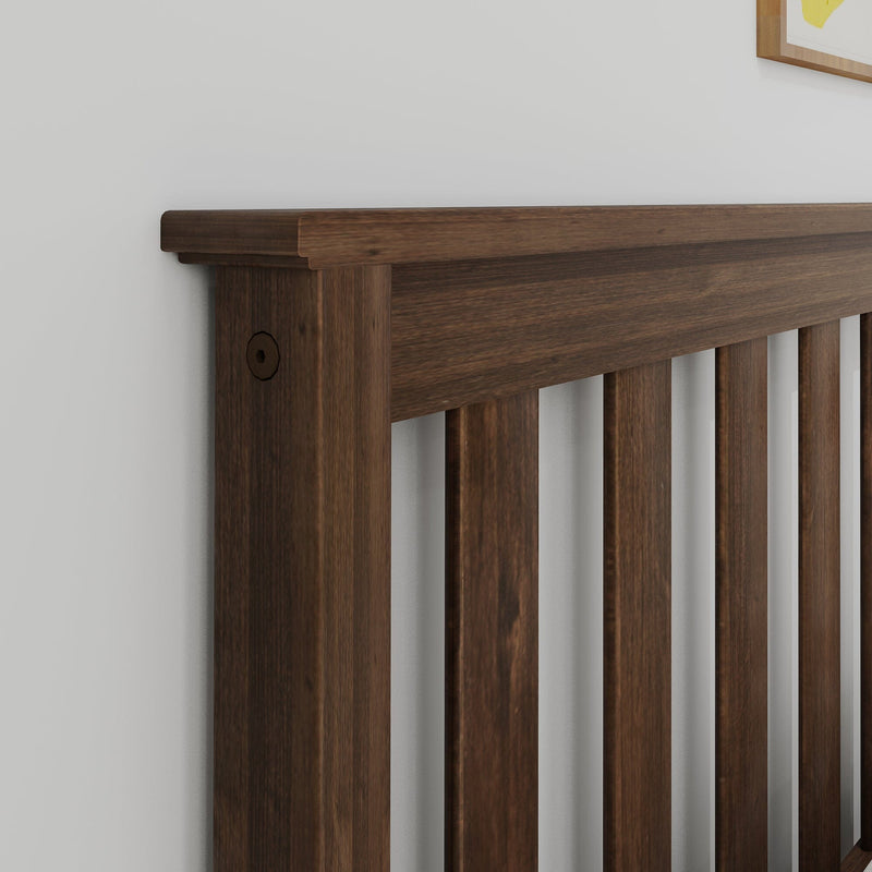 Dark walnut wooden slatted bed headboard close-up on white wall, modern bedroom furniture detail