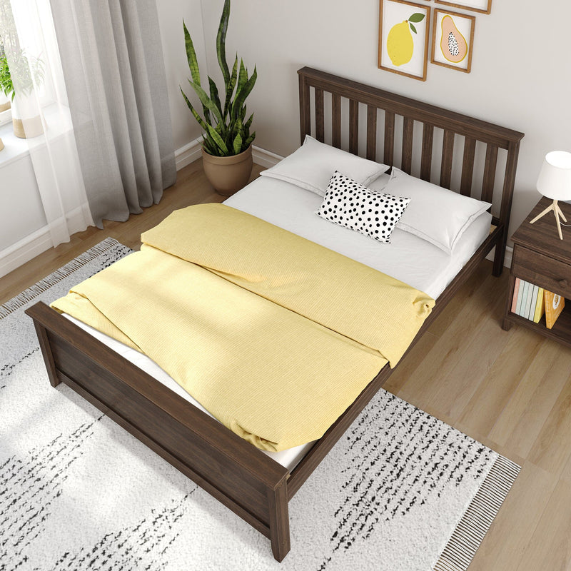 Modern bedroom decor with dark wooden bed frame, yellow duvet, polka-dot pillow, nightstand lamp, potted snake plant and framed fruit prints