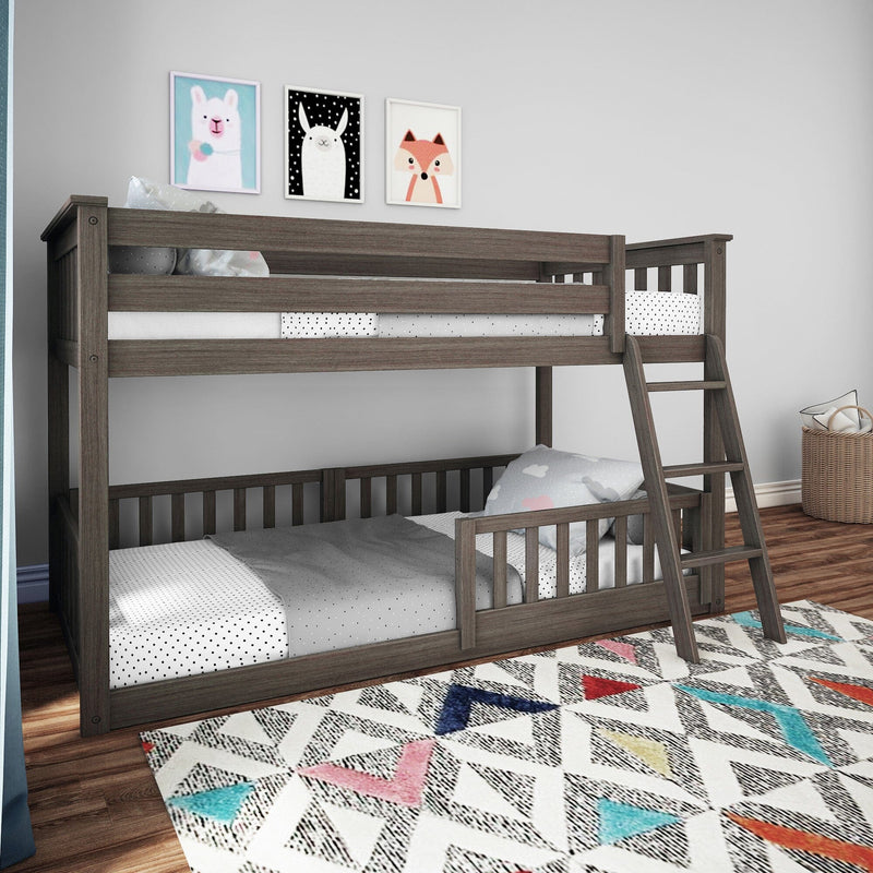 Gray wooden twin-over-twin bunk bed with ladder and safety rails in modern kids bedroom with polka-dot bedding, colorful geometric rug and animal wall art