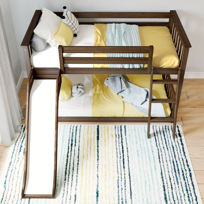 Modern wooden bunk bed with yellow bedding, light blue knit throw and decorative pillows on a striped area rug — stylish kids bedroom decor