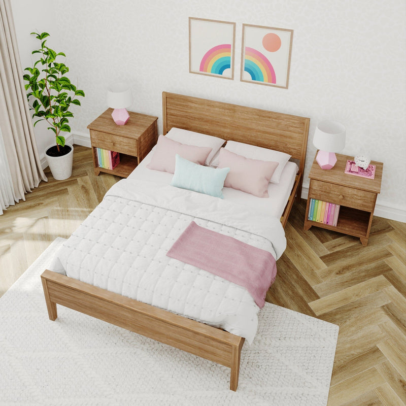 Cozy pastel bedroom with wooden platform bed, pink pillows and throw, matching nightstands with lamps, rainbow wall art and potted plant