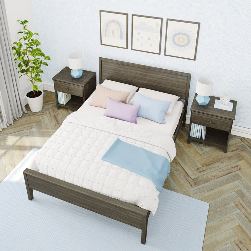 Modern light bedroom with dark wood bed frame, white quilt and pastel pillows, matching wood nightstands with blue geometric lamps, potted indoor plant, framed wall art, light blue patterned wallpaper and herringbone hardwood floor