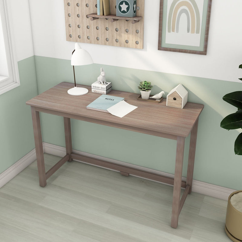 Minimalist wooden desk in bright home office with white desk lamp, notebook, succulent and decorative birdhouse against mint green wall