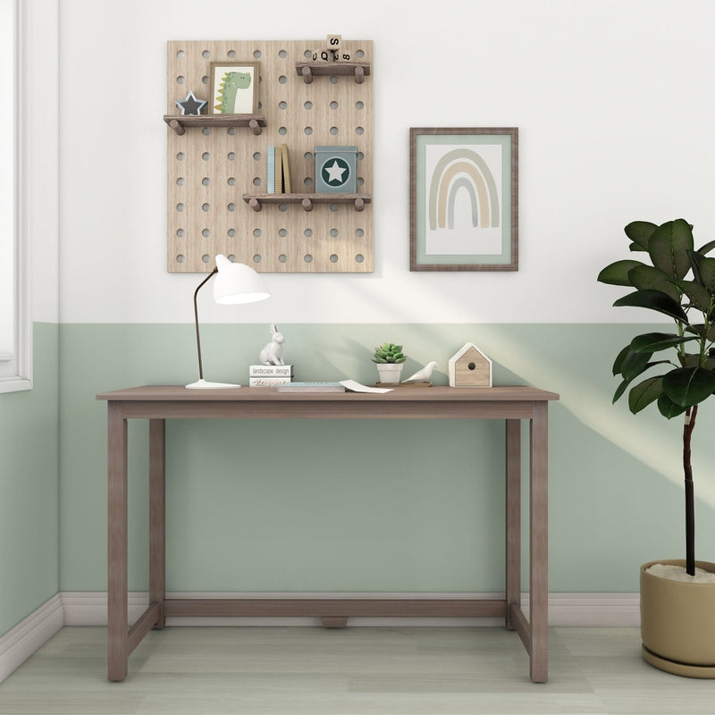 Minimalist wooden kids' desk with pegboard shelves, white desk lamp, framed rainbow print, succulent and potted plant against a pastel green nursery wall