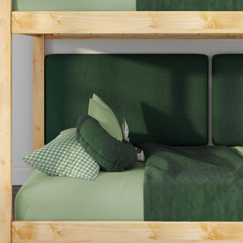Close-up of wooden bunk bed with green bedding, gingham pillow and dark green upholstered headboard