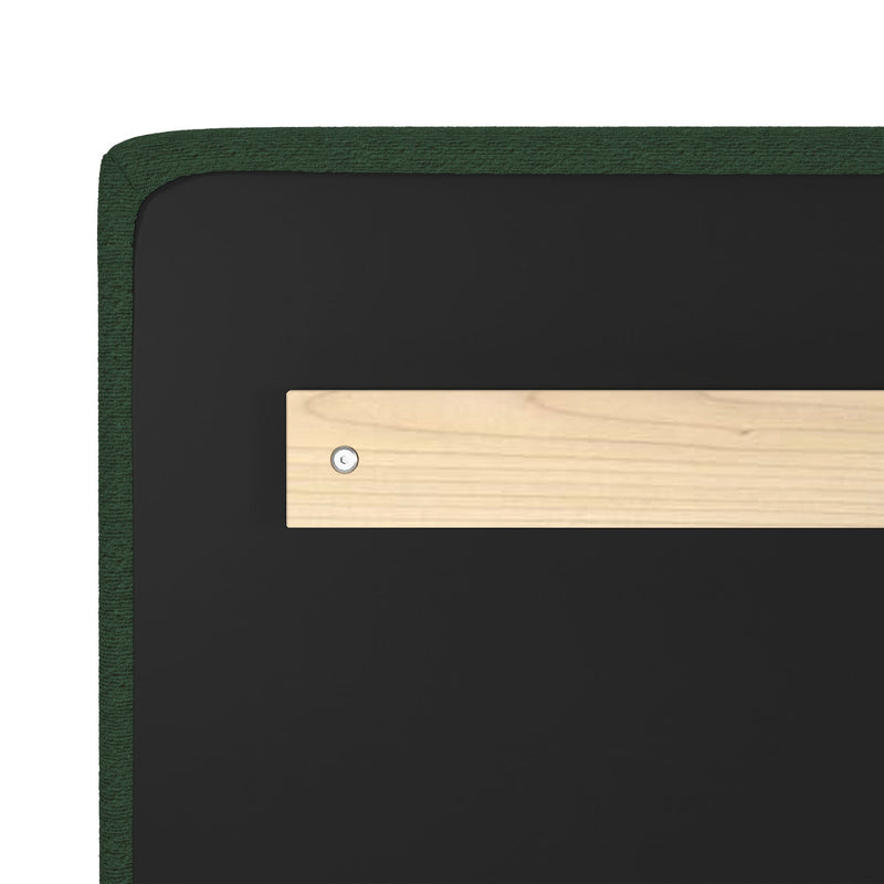 Close-up of green bouclé upholstered headboard corner with black backing and light wood support bracket secured by a metal screw