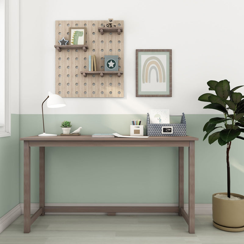 Children's study desk and pegboard shelves in pastel nursery — wooden desk, lamp, rainbow wall art, toy storage and plant