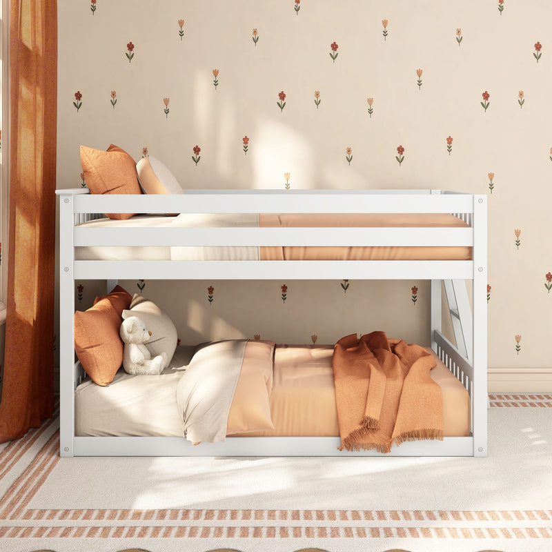 White wooden bunk bed in cozy kids bedroom with peach bedding, orange pillows, small floral beige wallpaper and plush teddy bear, nursery decor