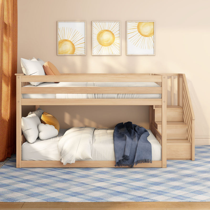 Modern wooden bunk bed with built-in stairs in a neutral kids' room, cozy white and orange pillows, sun-themed framed wall art, and blue plaid rug