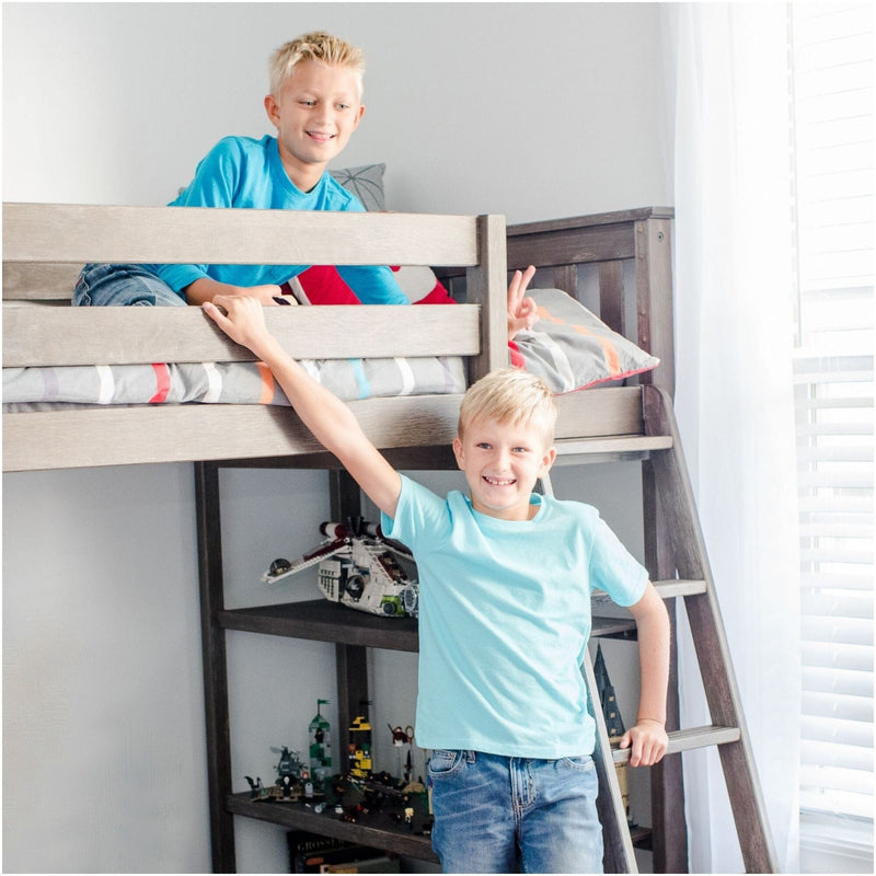 Two smiling boys on a gray wooden bunk bed with ladder in a bright kids' bedroom, LEGO toys and shelves visible below