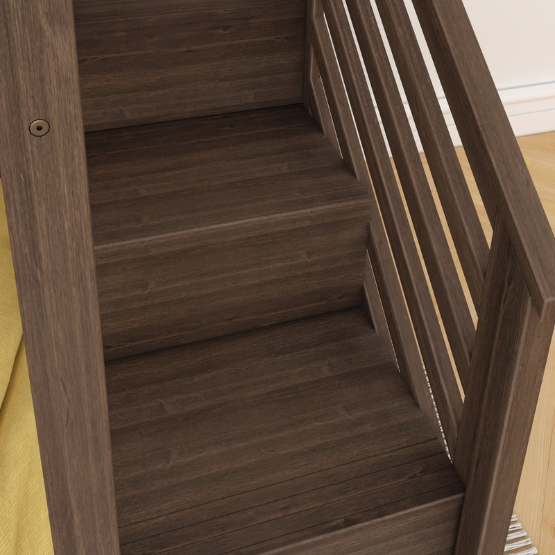 Close-up of dark walnut wood slatted crib or bed frame with yellow mattress and hardwood floor