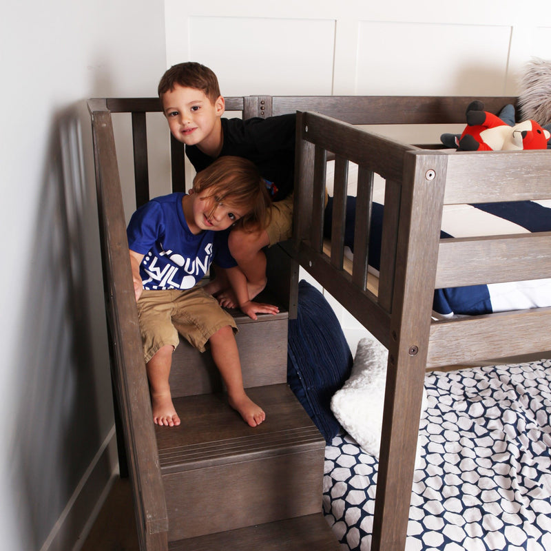 Two young boys playing on the stairs of a gray wooden bunk bed in a modern kids' bedroom with a plush toy.