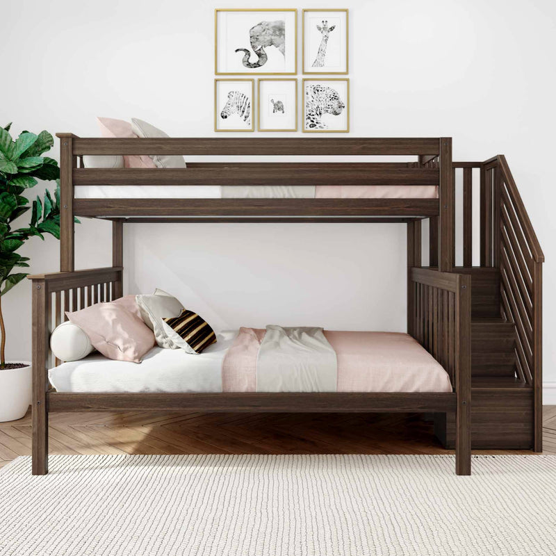 Modern dark wood twin-over-full bunk bed with built-in stairs, blush pink bedding and pillows, animal framed wall art, indoor plant and textured white rug in a kids' bedroom