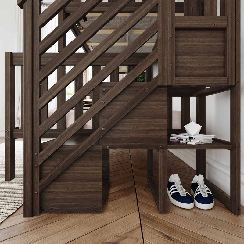 Dark brown wooden staircase railing with diagonal balusters and built-in under-stairs storage shelves holding blue sneakers and stacked magazines in a modern rustic entryway