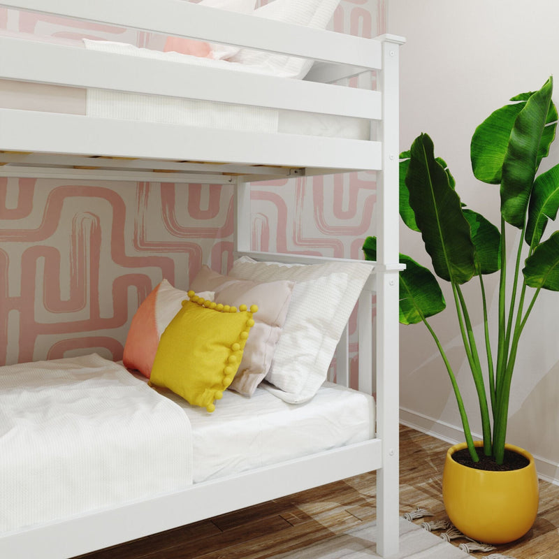 White wooden bunk bed with crisp white bedding and yellow pom‑pom pillow in a modern children's bedroom featuring pink geometric wallpaper and a large potted banana plant in a yellow planter