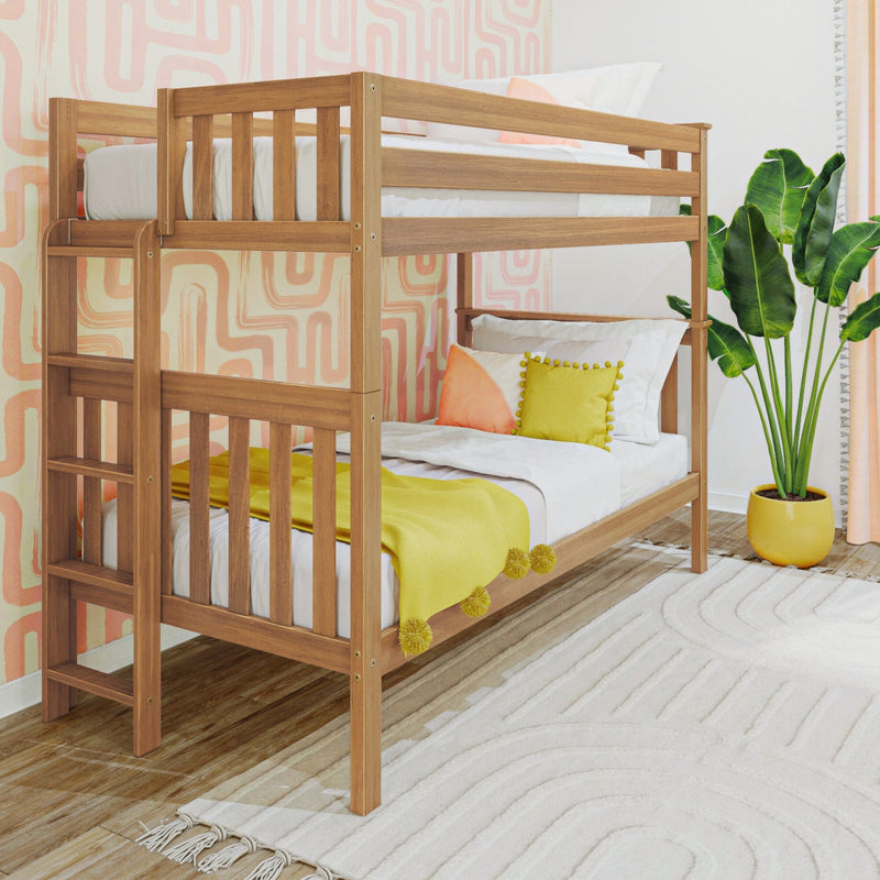 Natural wood bunk bed in colorful kids bedroom with pink geometric wallpaper, yellow throw and pillows, and potted plant