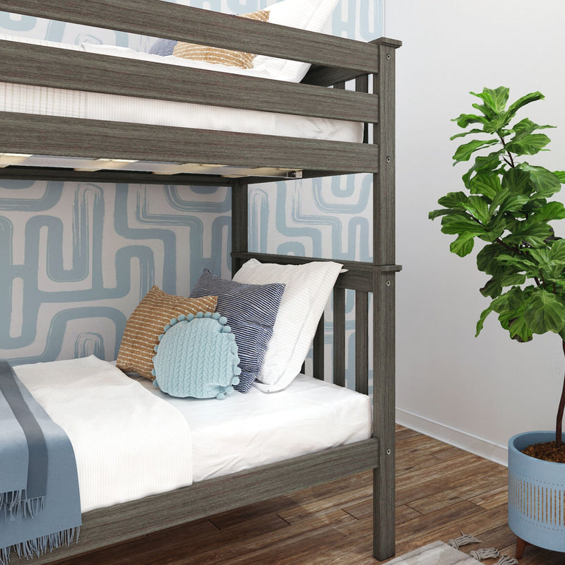 Grey wooden bunk bed in modern kids' bedroom with white bedding, blue and tan decorative pillows, blue geometric wallpaper, fiddle-leaf fig plant, and hardwood floor