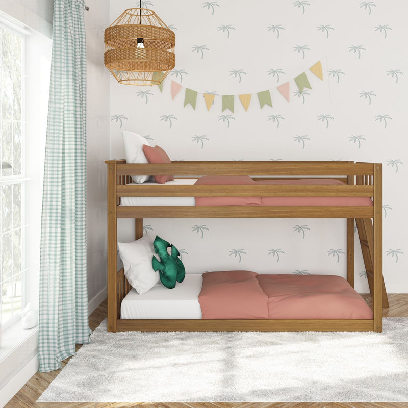 Wooden bunk bed in a pastel kids' bedroom with coral bedding, green dinosaur plush, gingham curtains, palm-print wallpaper, rattan pendant light and colorful bunting