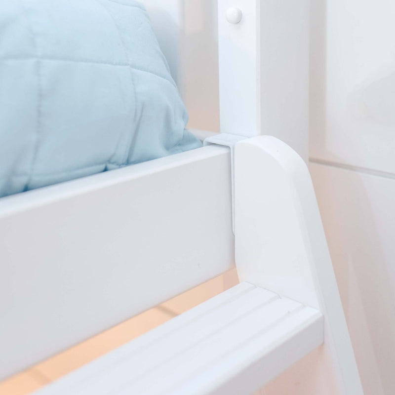 Close-up of white wooden bunk bed frame and safety rail with light blue quilted bedding in a minimalist nursery bedroom