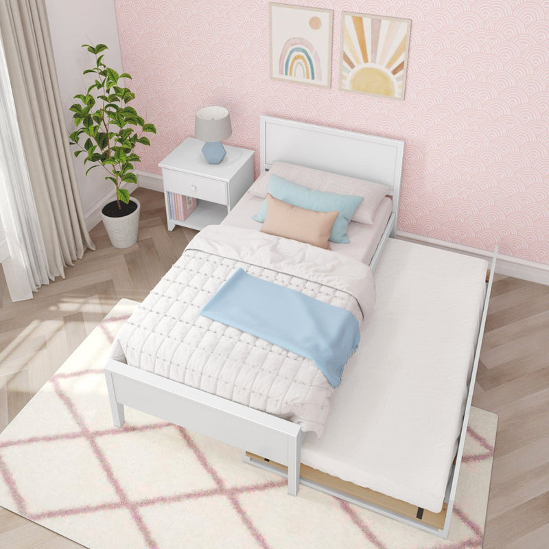 Girls bedroom with pink scallop wallpaper, white twin bed with pull-out trundle, pastel bedding, white nightstand, blue lamp and potted plant