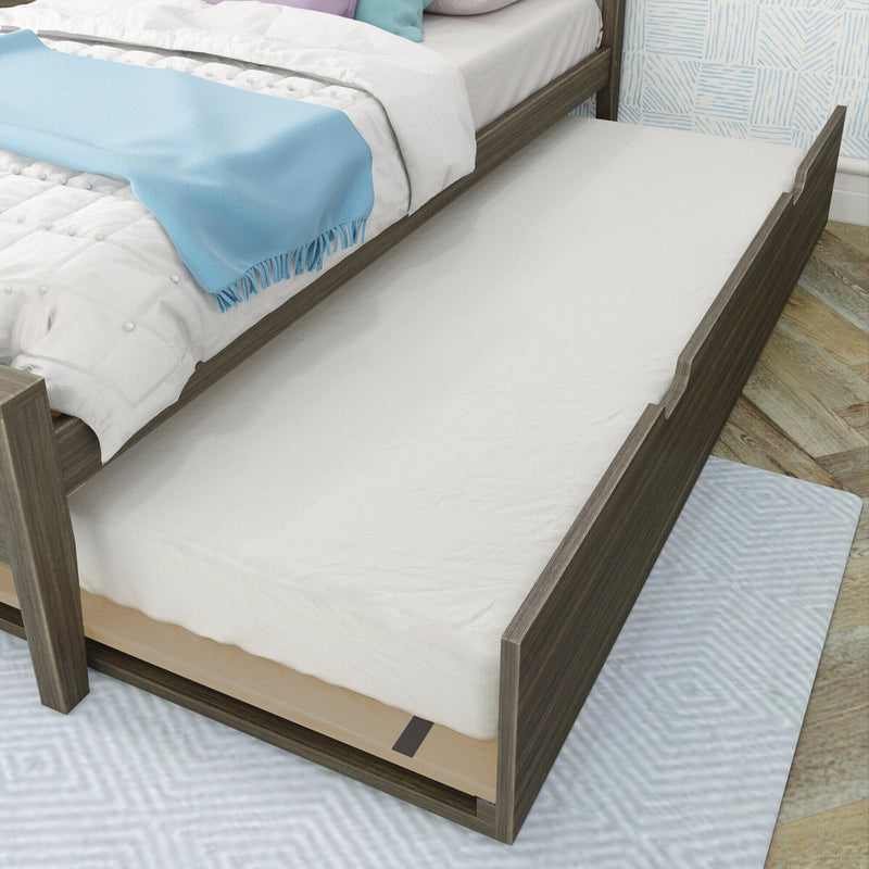 Dark wood twin trundle bed with pull-out mattress, white bedding and light blue throw blanket on hardwood floor in modern bedroom