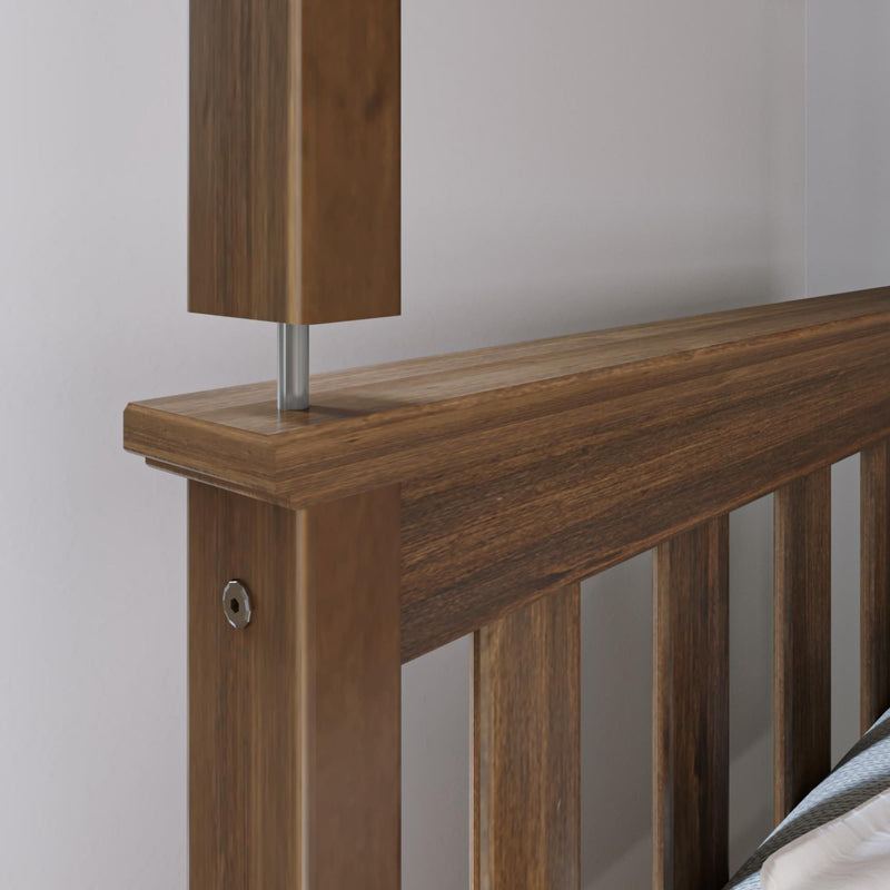 Close-up of wooden headboard with metal lamp post and white wall in modern rustic bedroom decor