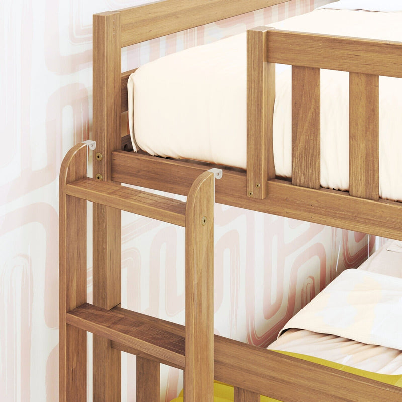 Close-up of a solid wood children's bunk bed safety rail and slatted frame in natural oak finish with white bedding and pastel pink abstract wallpaper
