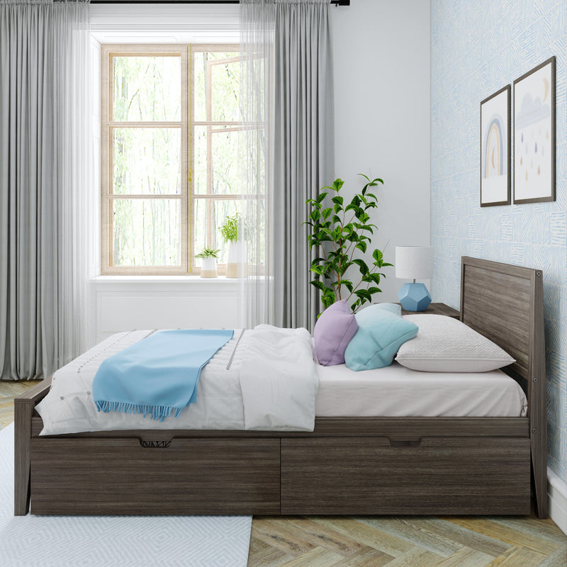 Modern light-filled bedroom with wooden platform bed, white bedding and blue throw, pastel pillows, geometric bedside lamp, potted plant by a large window with sheer and blackout curtains, and framed rainbow wall art